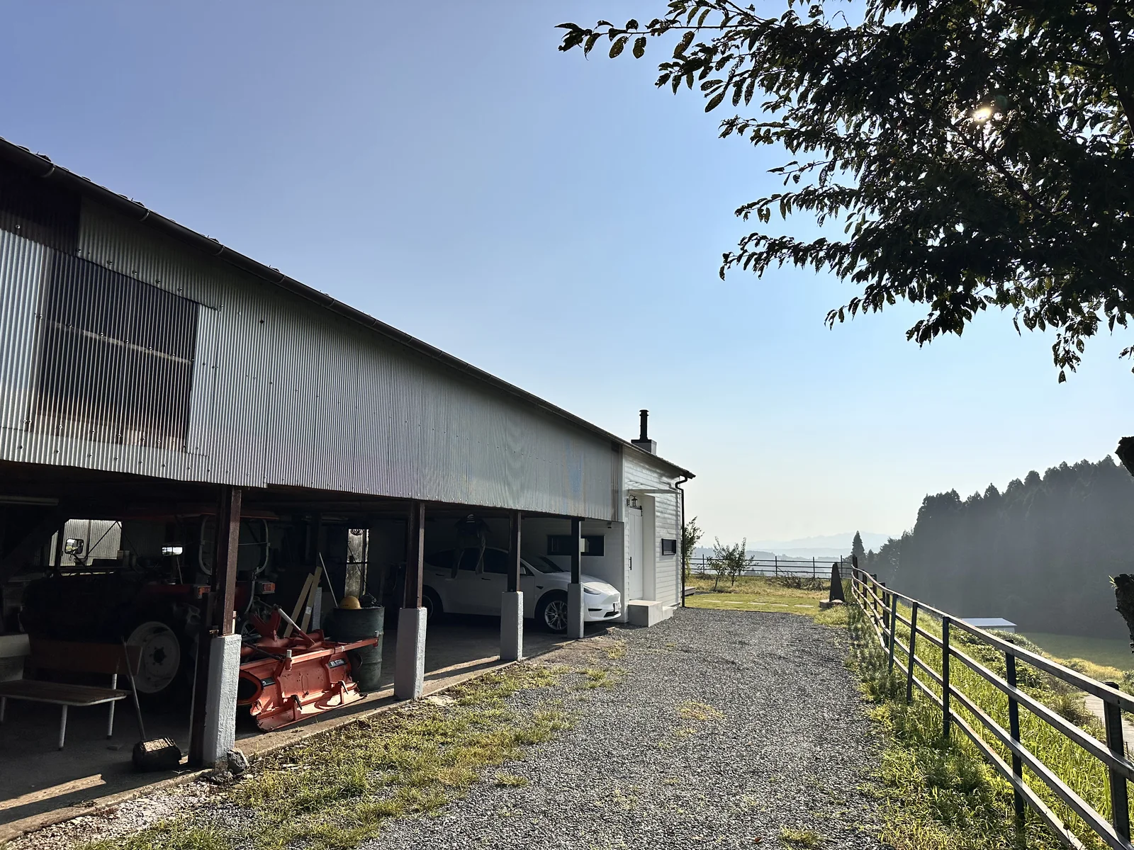 農業倉庫として使われる建物の外観とロッジへの道