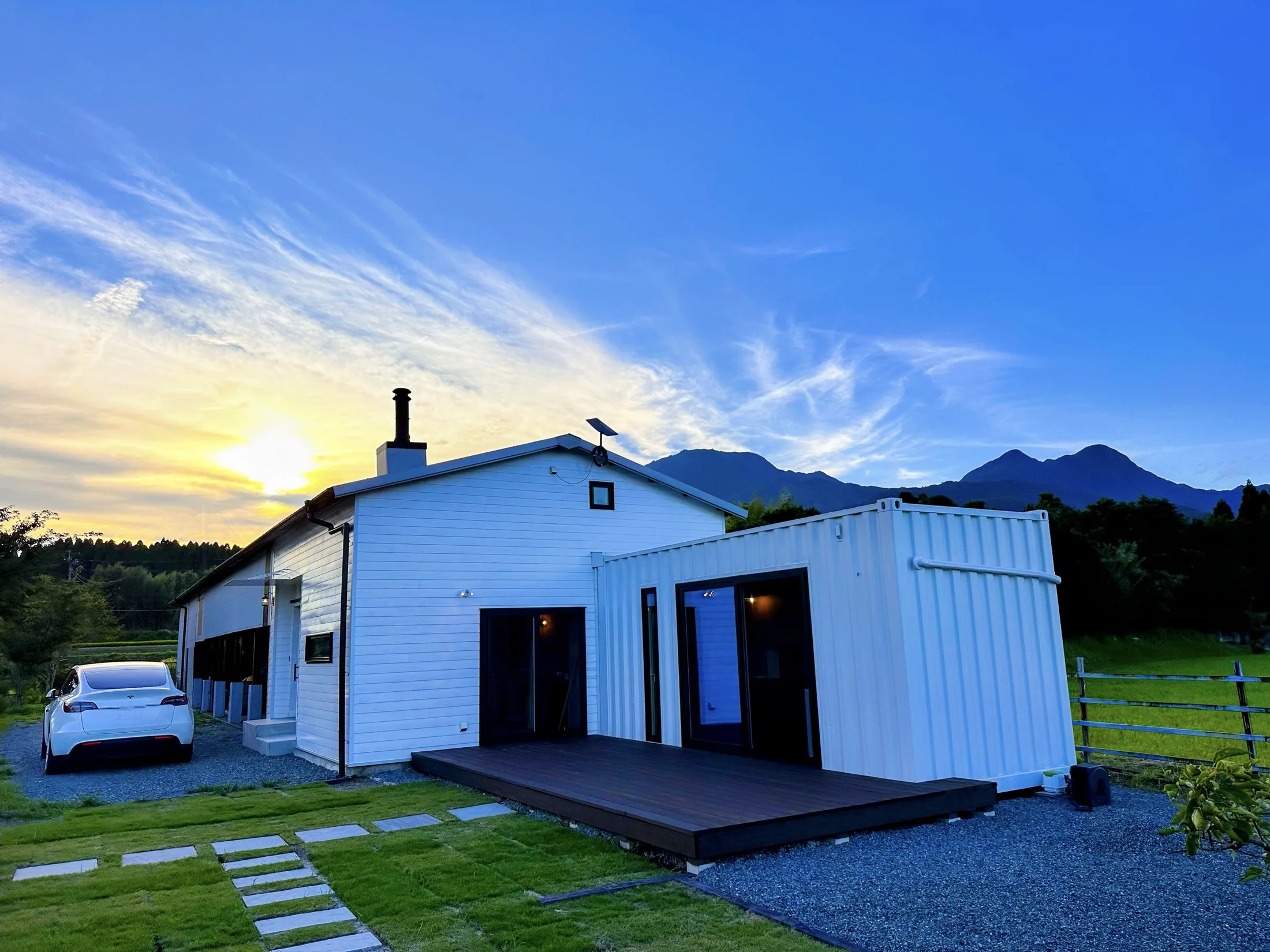 山並みと夕空を背にしたロッジとウッドデッキ